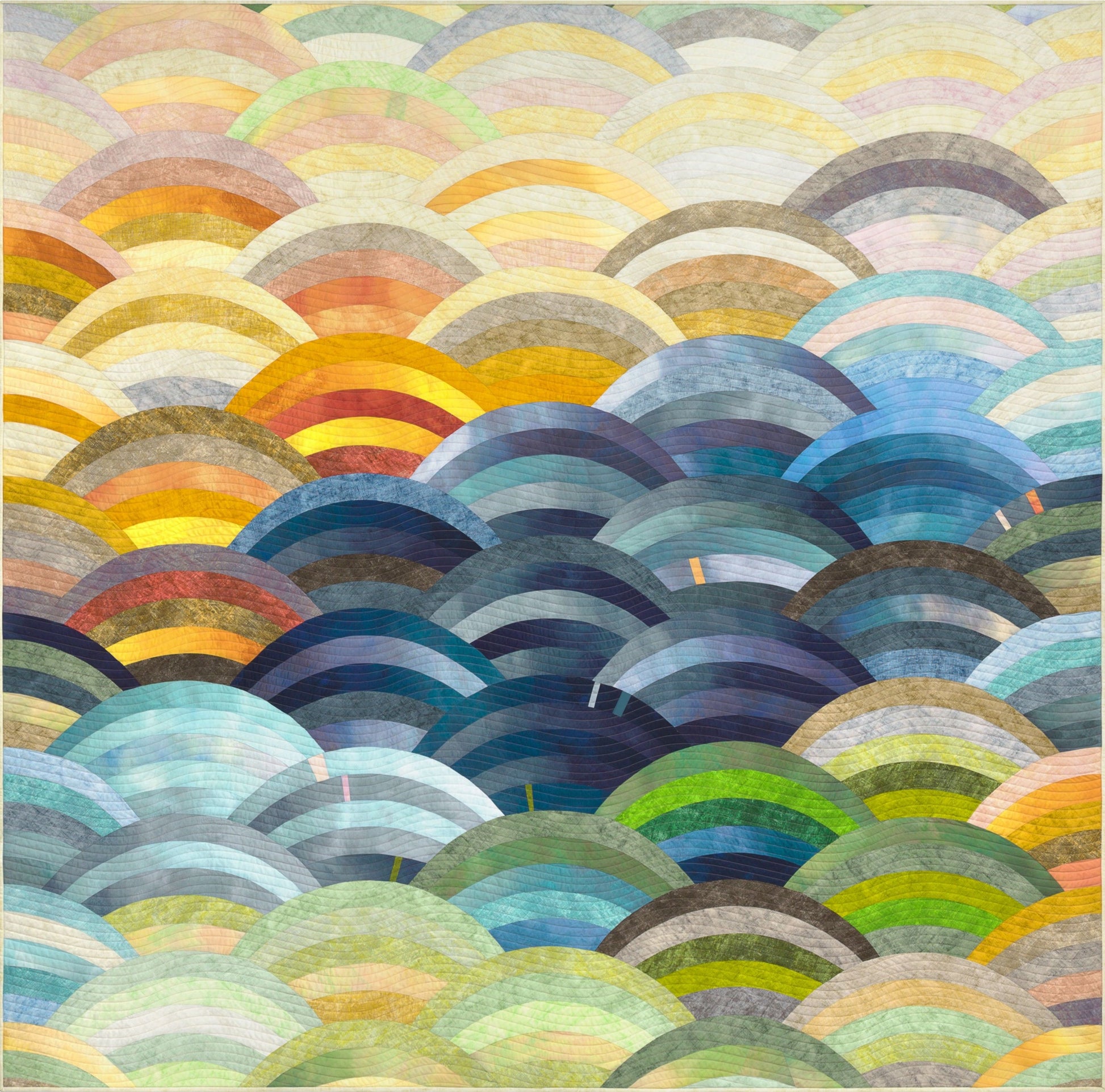 Hills Quilt kit featuring Sky Ombré Fabric and Chalk and Charcoal fabric, Colorful patterned fabric with circular designs in various shades of blue, green, yellow, and red. Molehills Quilt Pattern by Latifah Saafir.